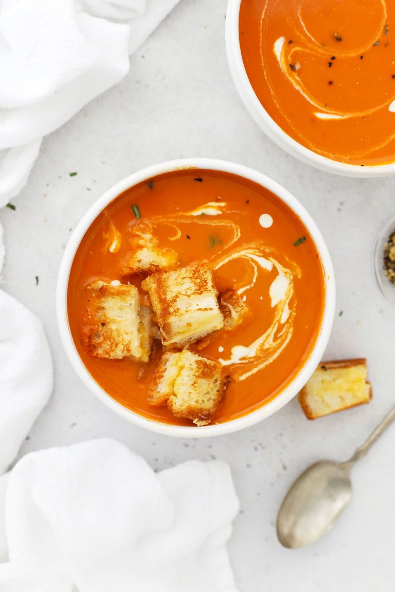 gluten-free tomato soup in white bowls with grilled cheese croutons