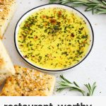 herbed dipping oil in a white plate surrounded by slices of gluten-free rosemary focaccia