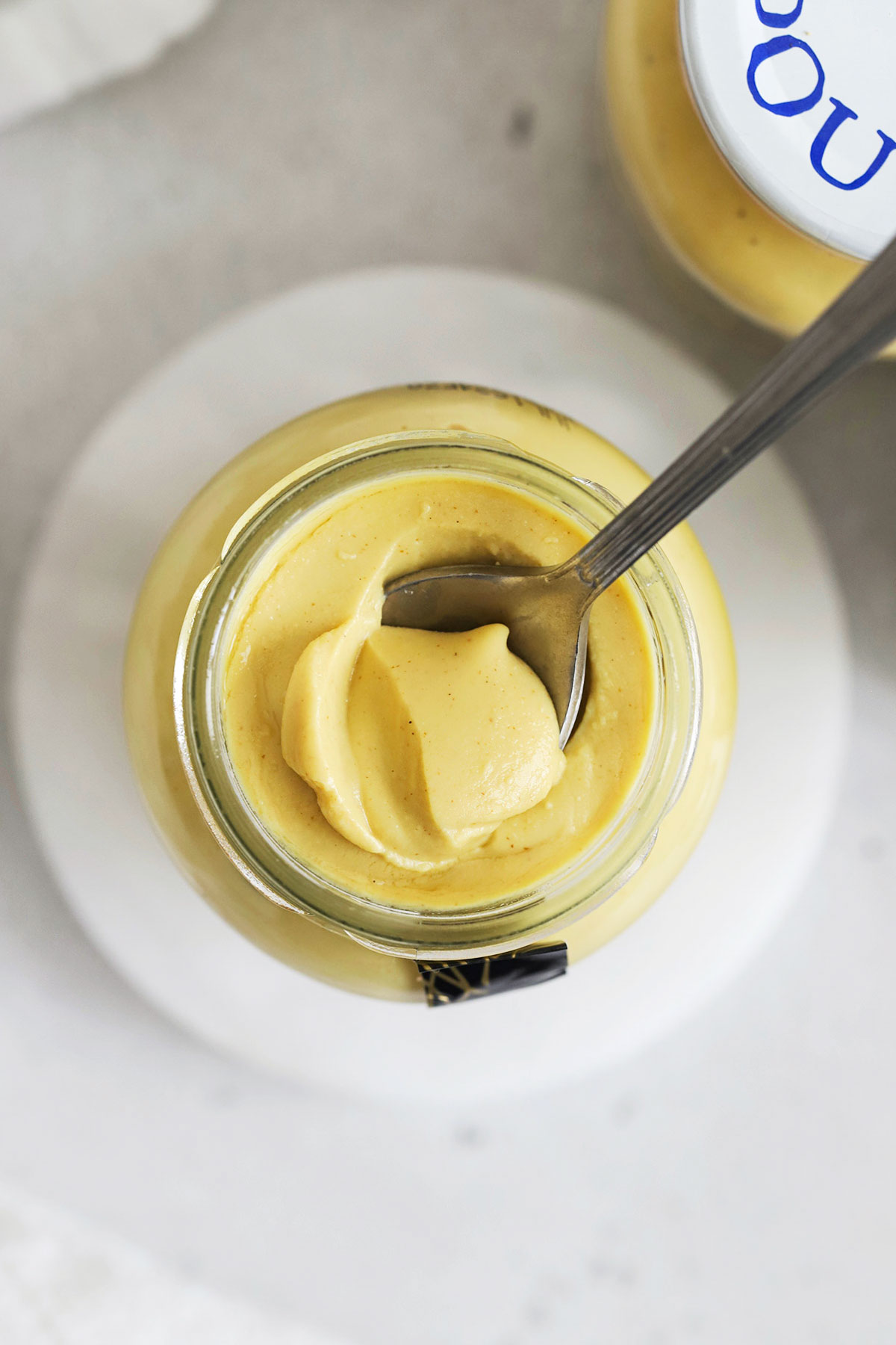 spoon scooping dijon mustard out of a jar