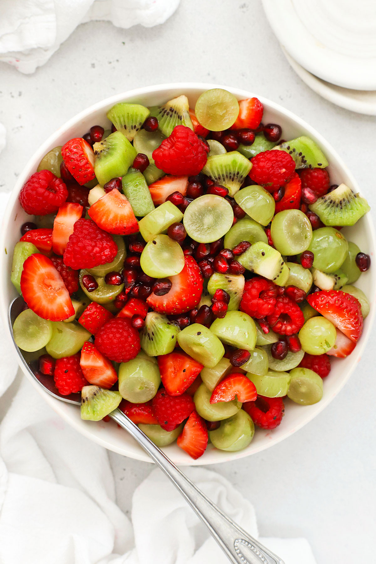 Christmas fruit salad with green grapes, strawberries, raspberries, pomegranate, and kiwi