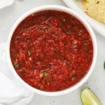homemade salsa in a white bowl next to tortilla chips
