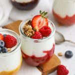 jars of homemade fruit on the bottom yogurt topped with gluten-free granola and fresh berries