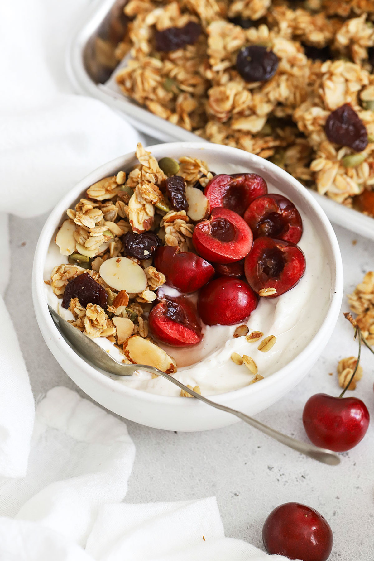 gluten-free cherry granola sprinkled on vanilla yogurt with cherries