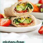 gluten-free turkey hummus wrap cut in half and stacked on a white plate