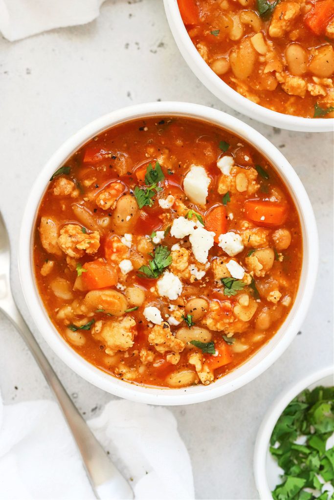 Bowls of buffalo chicken chili topped with cilantro and crumbled cheese