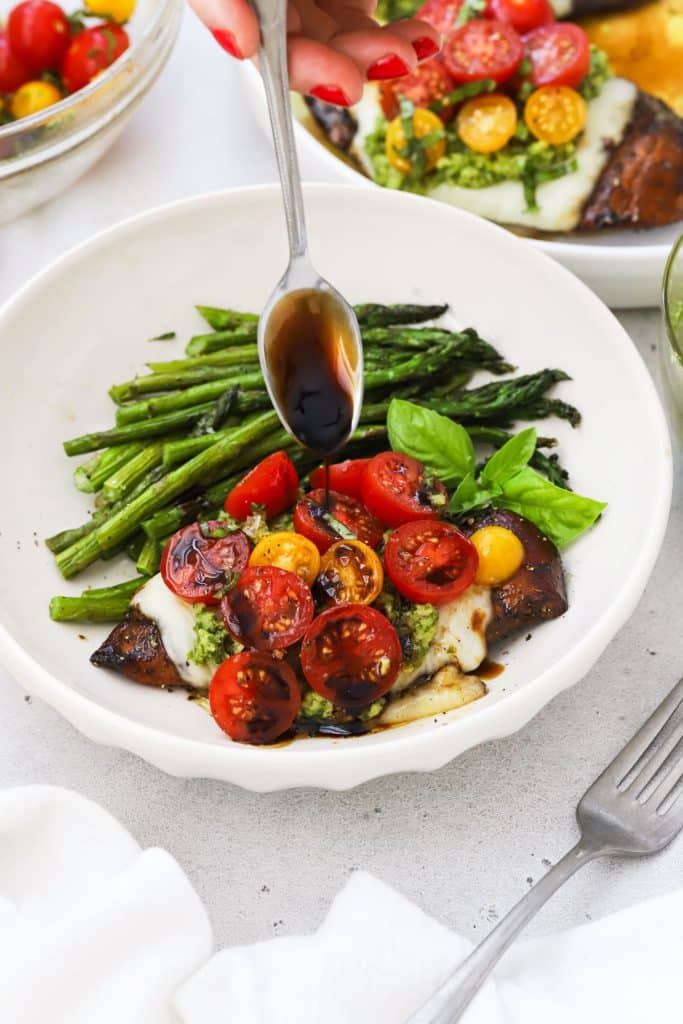 drizzling balsamic glaze on caprese chicken