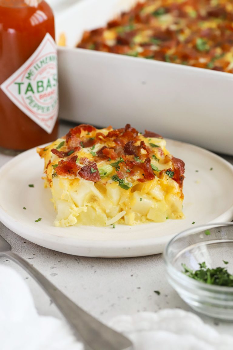 A slice of bacon potato breakfast casserole on a white plate