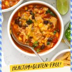 A bowl of cheesy chicken enchilada soup with black beans and cilantro