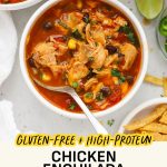 Spoon dipping into a bowl of healthy chicken enchilada soup