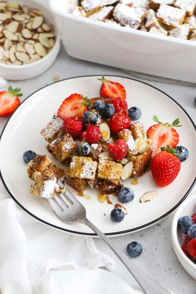 A plate of gluten-free French Toast Casserole topped with fresh berries and almonds