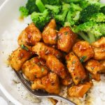 Fork tucking into a plate of healthy honey garlic chicken stir fry and rice