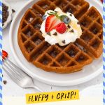 A plate of gluten-free chocolate chip waffles topped with whipped cream and fresh berries