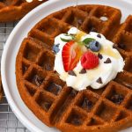Pouring syrup over gluten-free chocolate chip waffles