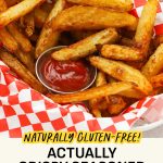 A basked of golden brown seasoned oven fries with a cup of ketchup