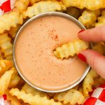 Dipping a french fry in a bowl of fry sauce