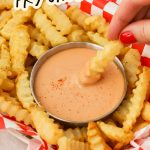 Dipping a french fry in a bowl of fry sauce