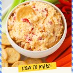 A bowl of homemade pimento cheese dip served with fresh veggies and gluten-free crackers