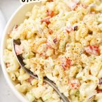 A serving bowl of gluten-free macaroni salad with creamy dressing and colorful veggies