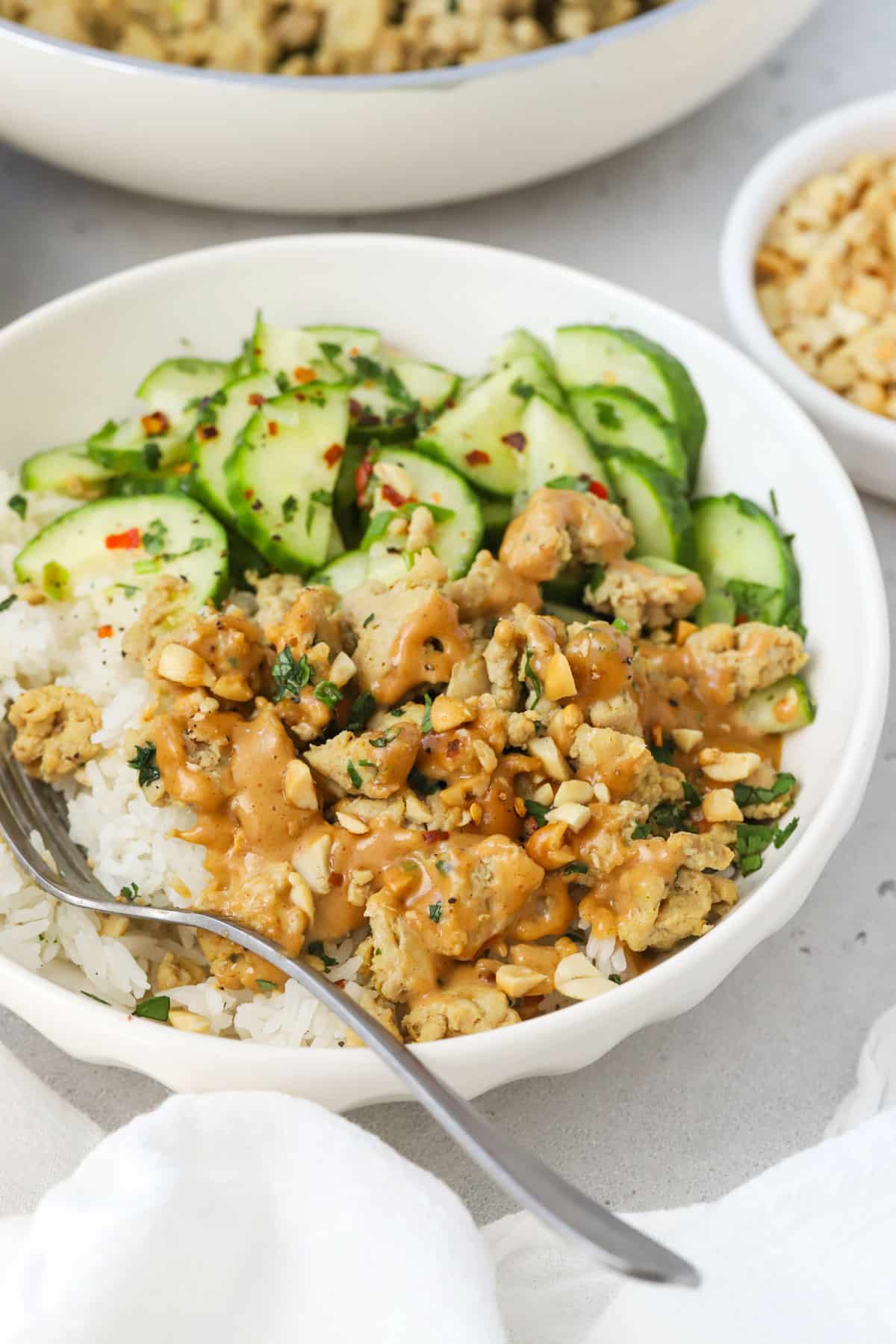 Peanut chicken bowls with ground chicken, jasmine rice, cucumber salad, and peanut sauce