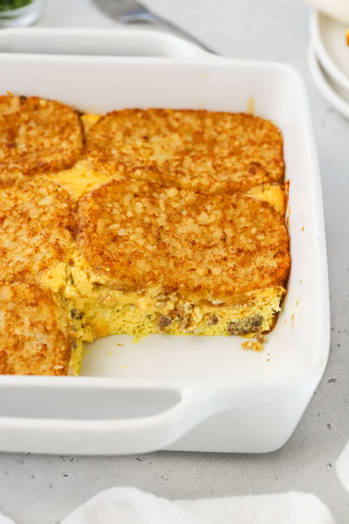 Hash brown patty egg bake in a white casserole dish