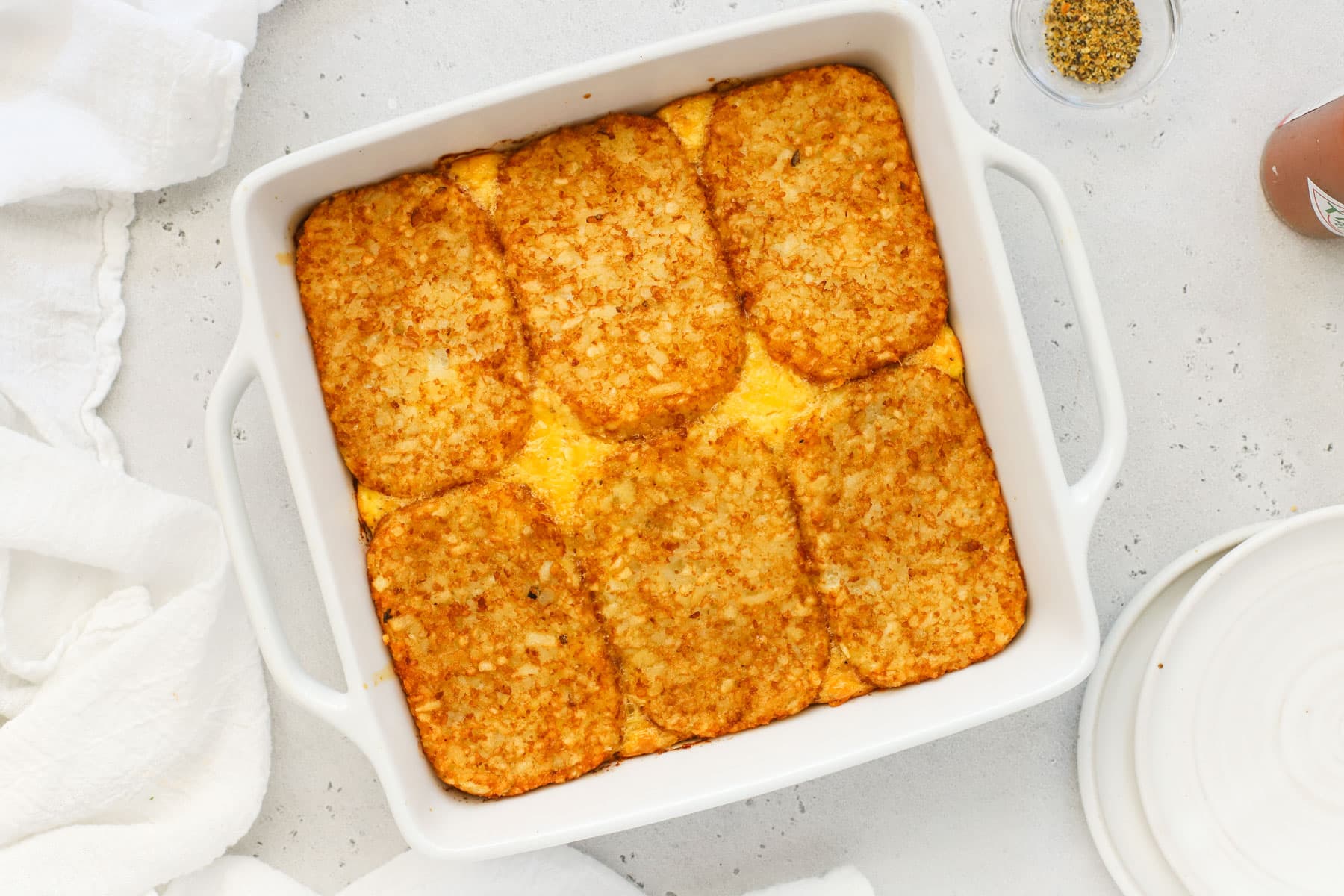 Hash brown patty egg bake in a white casserole dish