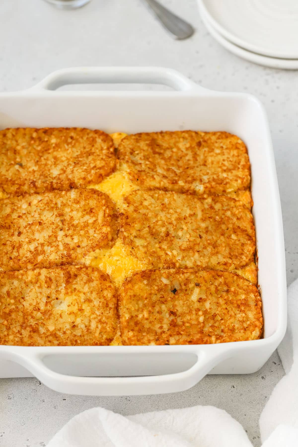 Hash brown patty egg bake in a white casserole dish