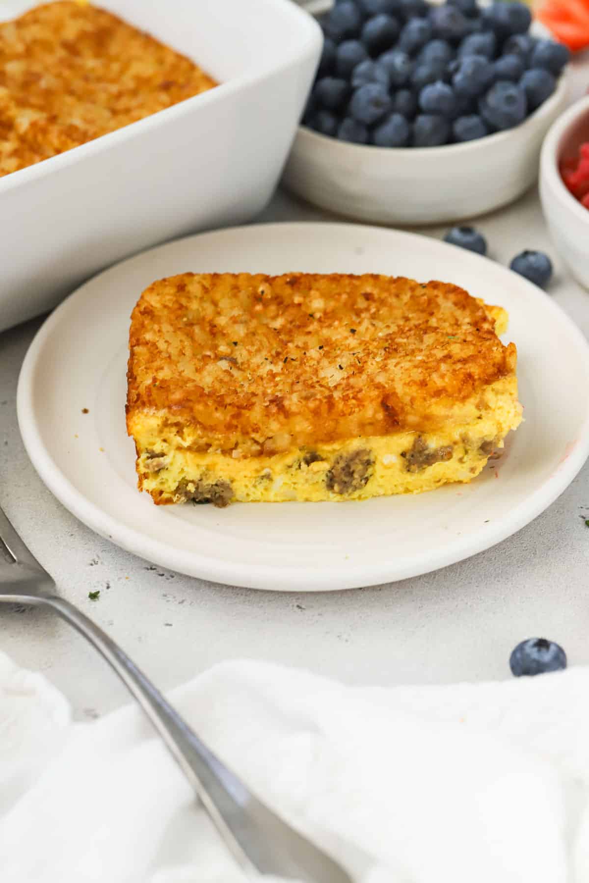 A slice of sausage hash brown egg casserole on a white plate