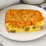 A slice of sausage hash brown egg casserole on a white plate