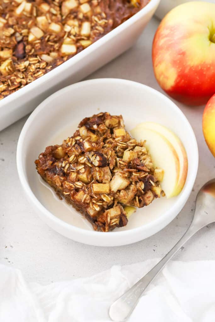 A bowl of apple cinnamon baked oatmeal with apple slices