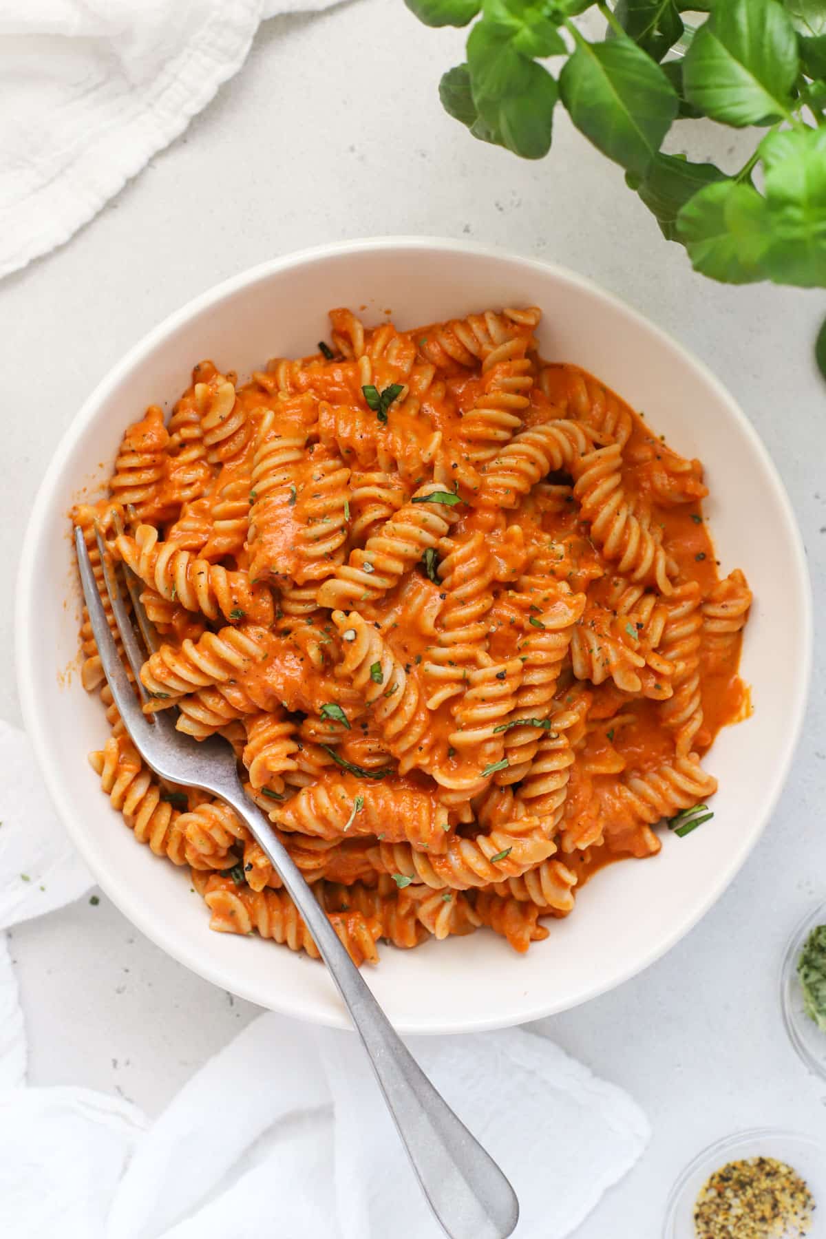 A bowl of pasta with creamy tomato sauce and fresh herbs