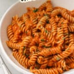 A bowl of pasta with creamy tomato sauce and fresh herbs