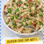 A bowl of parmesan pasta with peas and bacon