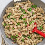 A pan of parmesan pasta with peas and bacon