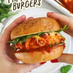 Holding a gluten-free chicken parmesan burger on a toasted gluten-free garlic bread bun